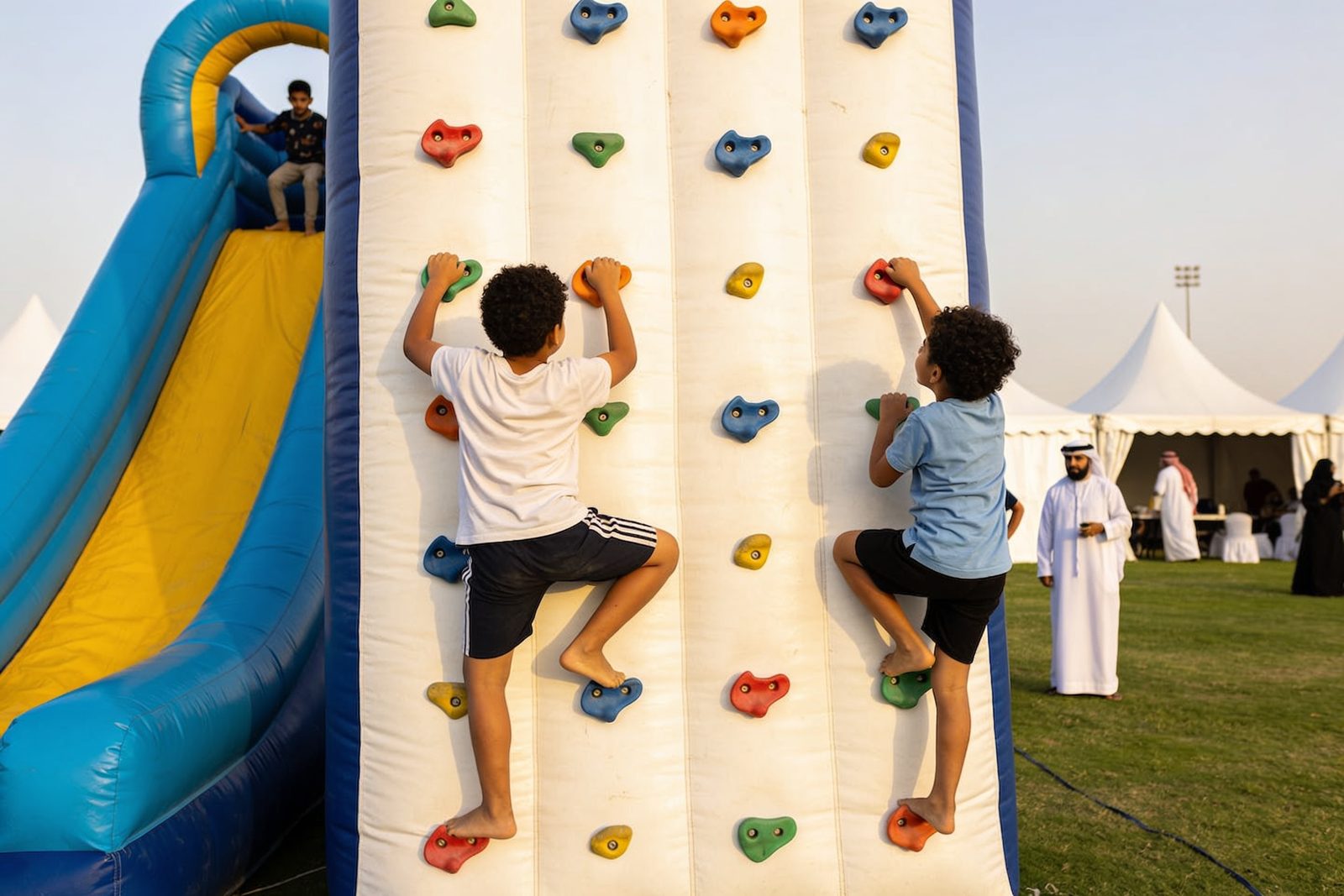 Kids climbing an inflatable climbing wall at a family day in Dubai