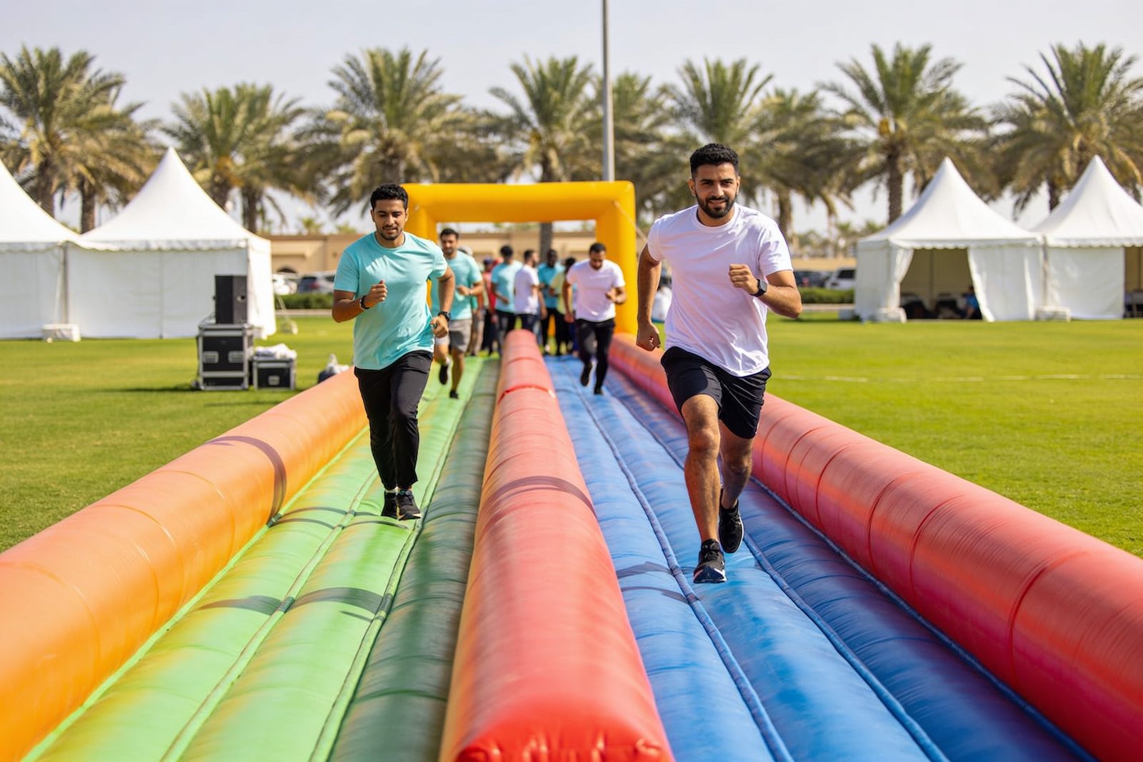 Adults racing on an inflatable obstacle course in Dubai