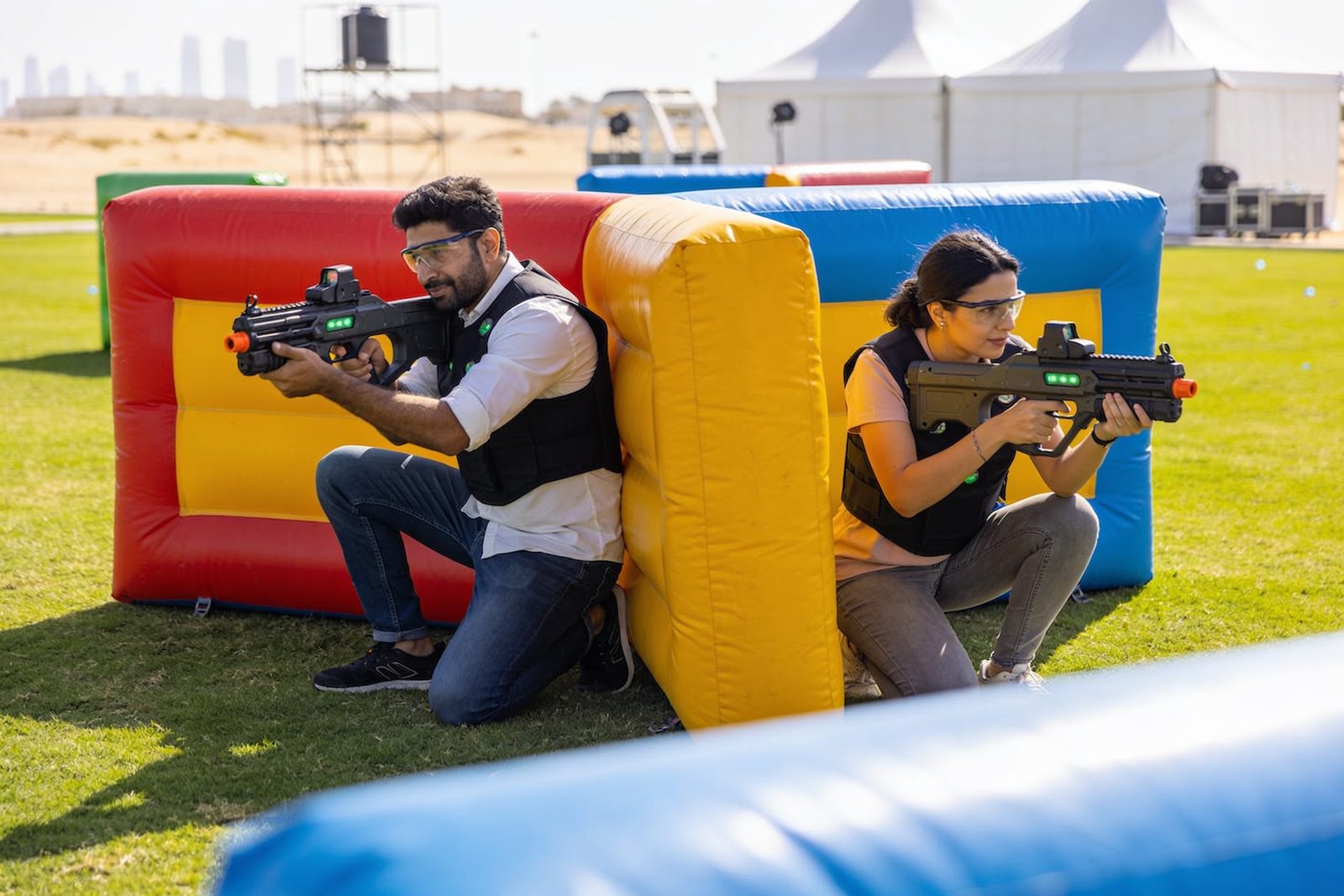 Teams playing mobile laser tag with inflatable bunkers in Dubai