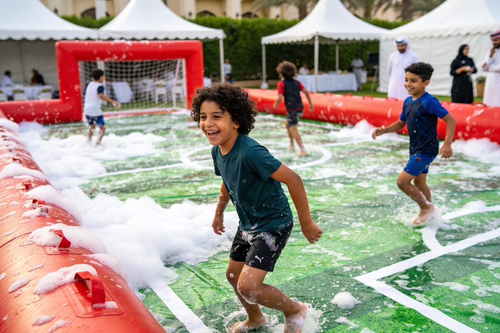 Children playing on a slippery inflatable football pitch in Dubai